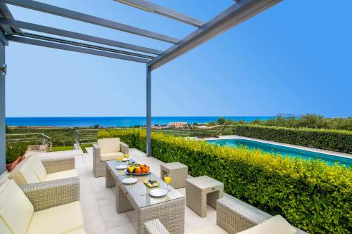 马莱迈Villa Dianna Maleme的一个带桌椅的庭院和一个游泳池