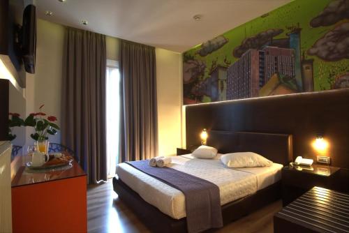 雅典雅典城市酒店的酒店客房设有一张床,墙上挂有绘画作品
