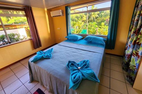 乌图罗阿FARE Miti en bord de mer Fare Tepua Lodge的一间卧室配有一张蓝色弓床