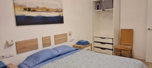 马德里Precioso apartamento recién reformado的卧室配有一张床,墙上挂有绘画作品