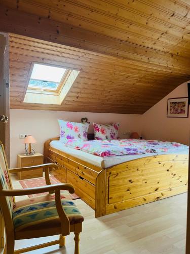 奥伯劳Hexen Haus的一间卧室配有一张木床和一把椅子