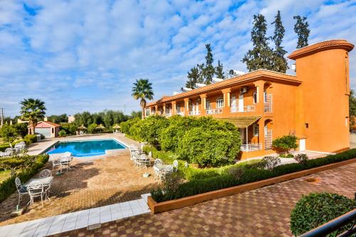 贝尼迈拉勒Complexe El Bassatine的一座大房子,在庭院里设有一个游泳池