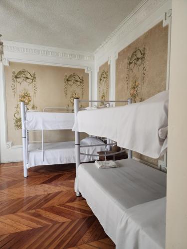 墨西哥城安妮斯旅馆的铺有木地板的客房内配有两张白色双层床。