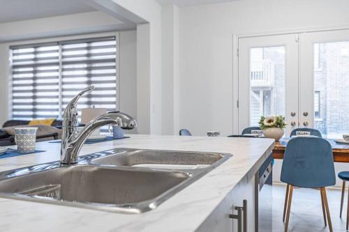 MidhurstCustom Build 5 Bedroom Villa (Ski Resort)的厨房配有不锈钢水槽和蓝色椅子