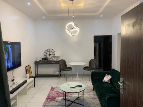 伊巴丹Luxury apartments的客厅配有绿色沙发和桌子