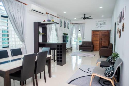 关丹CikJah Guest House SEMI-D的客厅设有餐桌和椅子