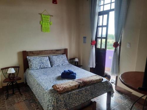 蒂拉登特斯Pousada Residência Balestra的一间卧室,配有一张蓝色帽子的床
