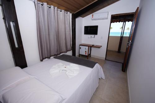 马塞约Pousada Girassol的卧室配有白色的床和电视。