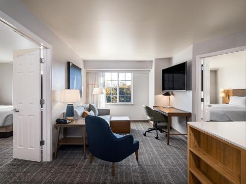 罗切斯特罗切斯特大学斯桥套房酒店的配有一张床和一张书桌的酒店客房