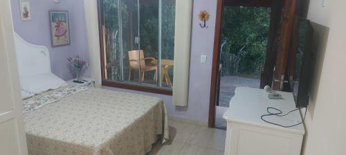 安谢塔CHALÉ Pedaço do Coqueiro的一间卧室配有一张床,享有庭院的景色