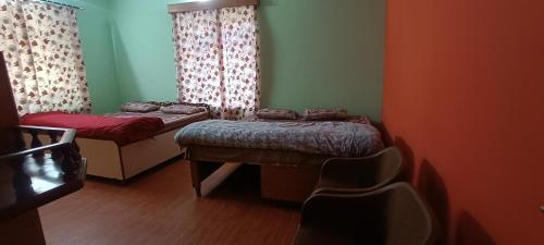 西姆拉Akash Homestay的一间设有两张床和椅子的房间