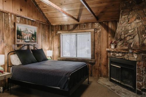 大熊湖2411 - Oak Knoll Duplex Studio #14 cabin的一间卧室配有一张床和一个壁炉