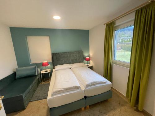 奥西亚歇尔湖畔施泰因多夫阿姆西公寓的卧室配有床、椅子和窗户。