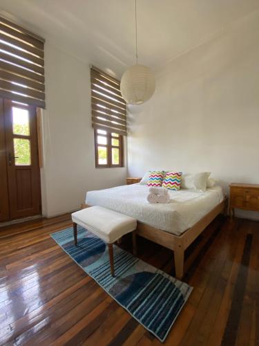 圣地亚哥Castelletto Bed & Breakfast的卧室配有床、长凳和窗户。