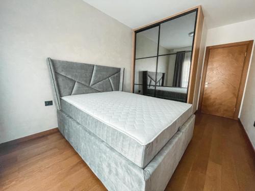 波德戈里察Apartman Terra的一张大床,位于带镜子的房间里