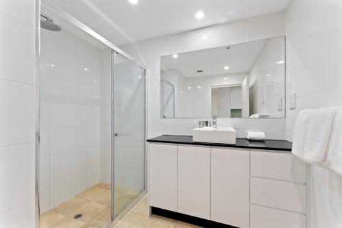 悉尼达令港APX公寓式酒店的白色的浴室设有水槽和镜子