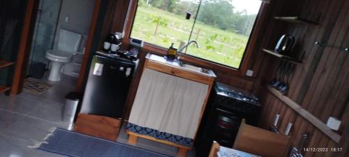 因比图巴Arandu Chalés的厨房配有水槽、冰箱和窗户。