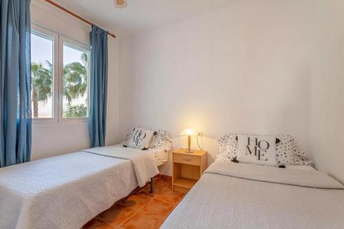 穆特克萨梅尔Golf Bonalba Alicante "Servall Host"的带窗户的客房内的两张床