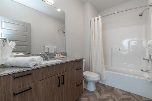 乌尔班纳Yugo Guest Suites的带浴缸、卫生间和盥洗盆的浴室
