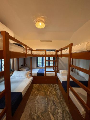 瓦尔卡拉The Barefoot Varkala的客房设有三张双层床和吊灯。