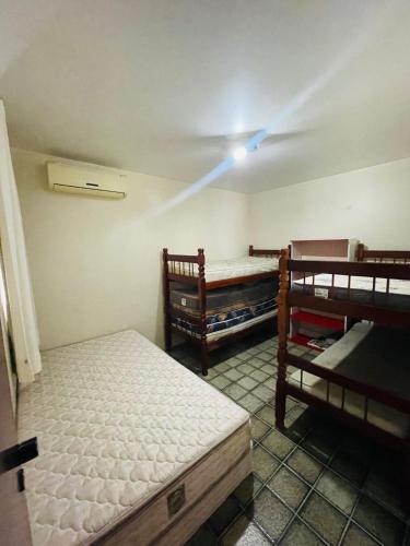 拉巴拉德纳圣米格尔Condomínio Rochas do Mar的客房设有两张双层床和天花板。