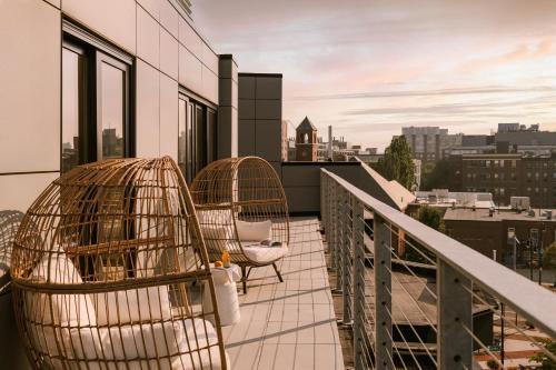 剑桥Sonder 907 Main的大楼内的阳台配有两把鸟笼和椅子