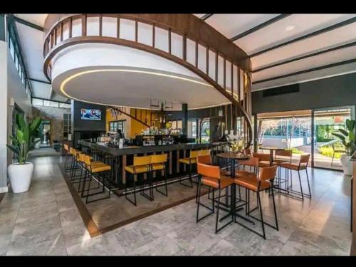 米德兰URlyfstyle Cottage @ Kikuyu waterfall的用餐室设有带黄色椅子的酒吧