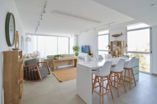 朱拜勒Amchit Bay Beach Residences 3BR Rooftop w Jacuzzi的厨房以及带桌椅的起居室。
