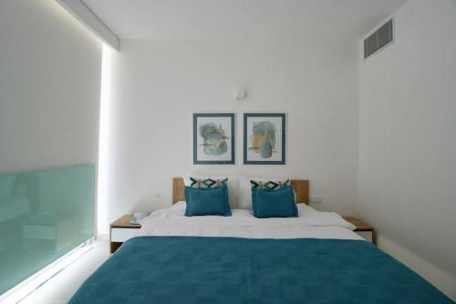 朱拜勒Amchit Bay Beach Residences 3BR Rooftop w Jacuzzi的一间卧室配有一张带蓝色枕头的大床