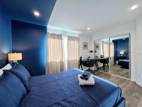 洛杉矶Trendy 2BR Near Hollywood Hotspots - BR9的蓝色卧室配有一张床和一张书桌