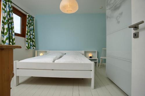 韦斯特兰Captain's Lounge - Bungalow XL的一间白色卧室,房间内设有白色的床