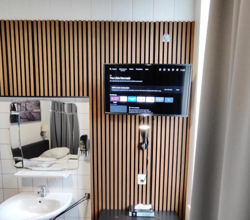 乌得勒支荷兰旅舍酒店的一间带水槽的浴室和墙上的电视