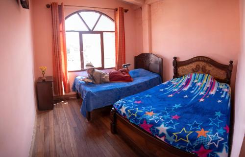 科帕卡巴纳Ima Sumaj Hostel的一间卧室配有两张床,床上放着一只狗。