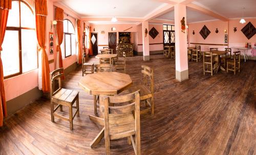 科帕卡巴纳Ima Sumaj Hostel的餐厅设有木桌、椅子和窗户。