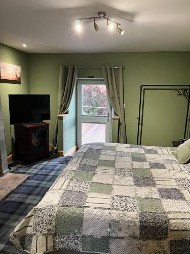 霍特惠斯尔White Side Cottage的一间卧室配有一张床、一台电视和一个窗口