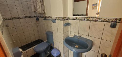 奥克萨潘帕Hospedaje Olguita的浴室配有蓝色水槽和卫生间。