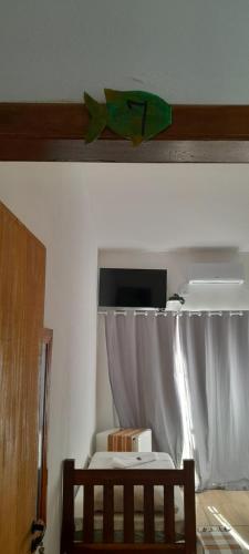 帕拉蒂Pousada Pé na Areia的一间卧室配有一张带窗帘的床和电视