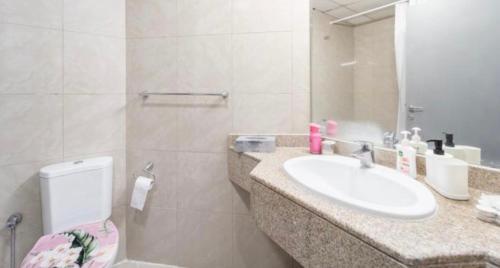 迪拜Greatest location Dubai的一间带水槽、卫生间和镜子的浴室