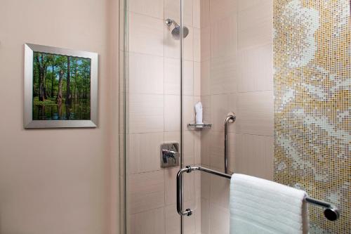 新奥尔良新奥尔良法国区/伊贝维尔万怡酒店的带淋浴的浴室,毛巾架上配有毛巾