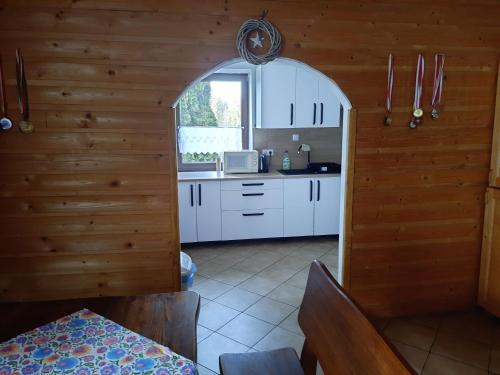 伊斯泰布纳Pokoje u Juroszka的厨房配有白色橱柜和窗户。