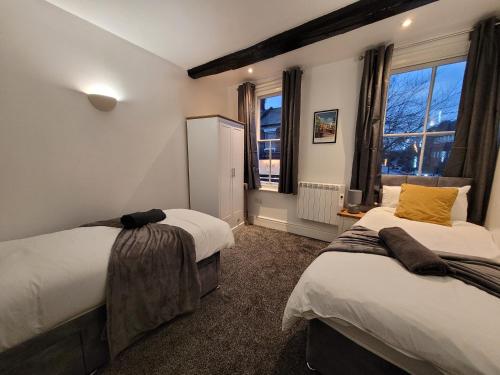 科尔切斯特Wallgate House Apartments- Step back into Roman history with Catchpole Stays的一间卧室设有两张床和窗户。