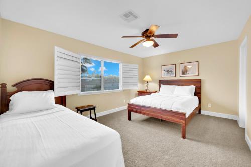 拉斯维加斯Oasis Retreat at Henderson Greens的一间卧室配有两张床和吊扇
