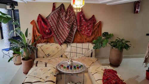 马拉喀什Riad Soir De Marrakech的客厅配有带枕头和植物的沙发