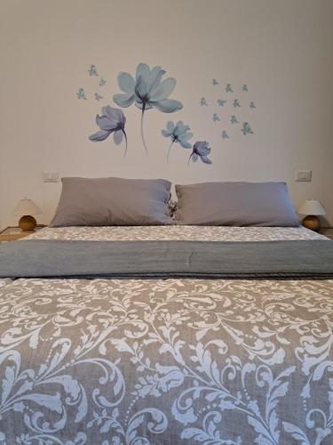 Casale Corte CerroLa casa di Noemi的卧室配有一张挂着蓝色鲜花的床。