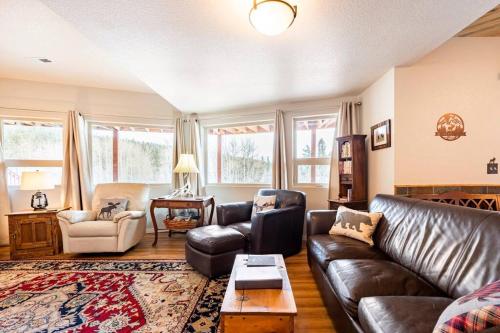 布莱克霍克Meandering Moose Apartment的客厅配有真皮沙发和桌子