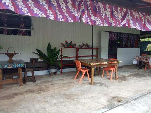 HaapuRavehei smile relais 3 Huahine的配有桌椅和国旗的房间