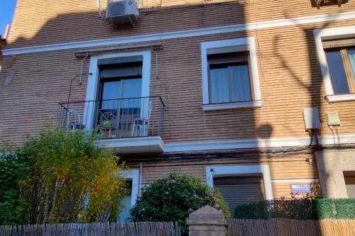 萨拉戈萨Apartamento Turístico Zaragoza的一间棕色砖屋,前面有栅栏