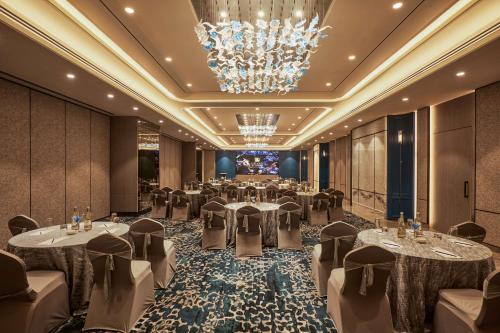 孟买孟买哥熱岗丽笙酒店的宴会厅配有桌椅和吊灯。