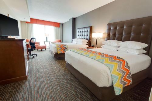 迈尔斯堡Drury Inn & Suites Fort Myers Airport FGCU的酒店客房设有两张床和电视。