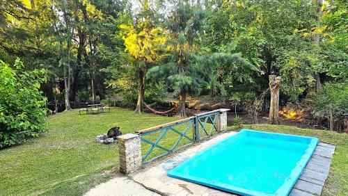 贝纳维德斯Casa con PILETA al borde del RIO的公园旁的院子内的游泳池